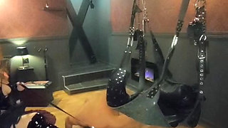 Mistress Acanthus raises her slave on a leash to the whip on the cross