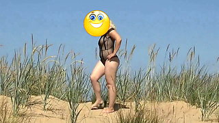 Pretty woman in a nylon bodysuit on the beach