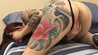 Redhead slut with tattoos all over her body rides a dildo